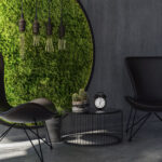 Two chairs with coffee table standing by round moss wall art